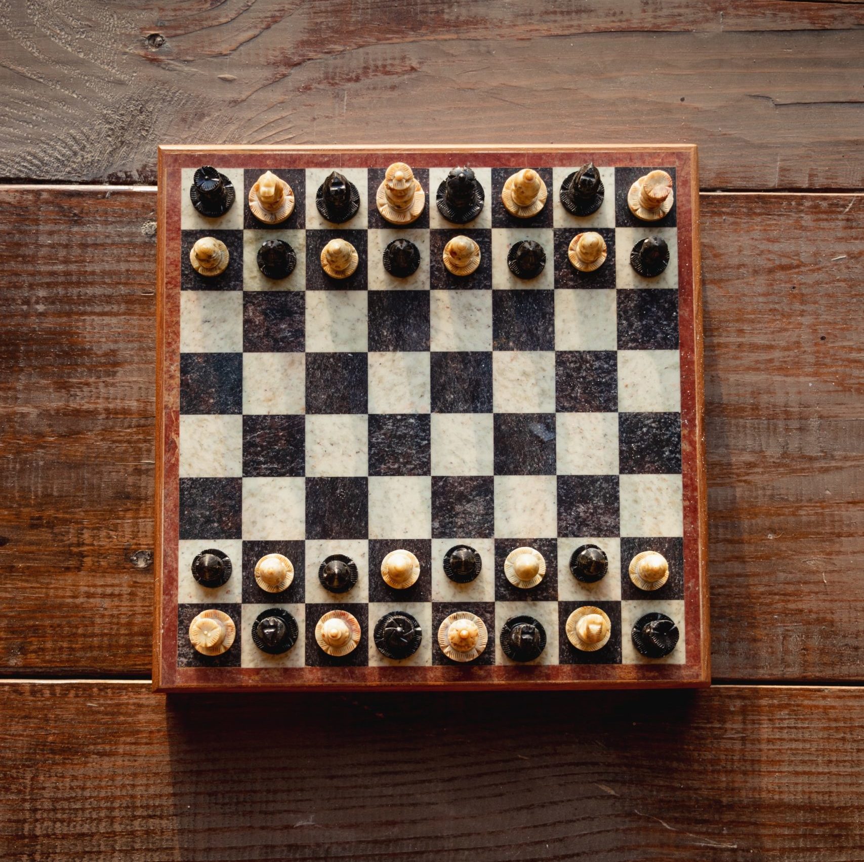 Chess board with alternating black and white pieces on each side